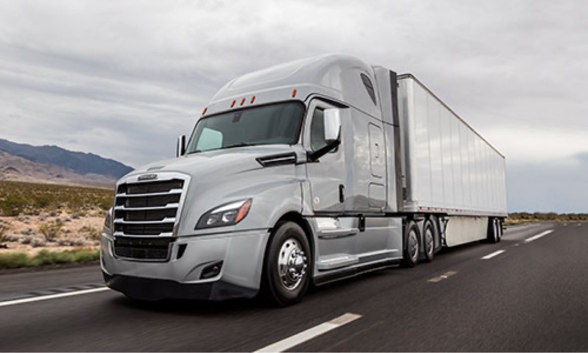 Silver Freightliner Cascadia sleeper truck pulling a clean white 53-foot dry van trailer on a desert highway